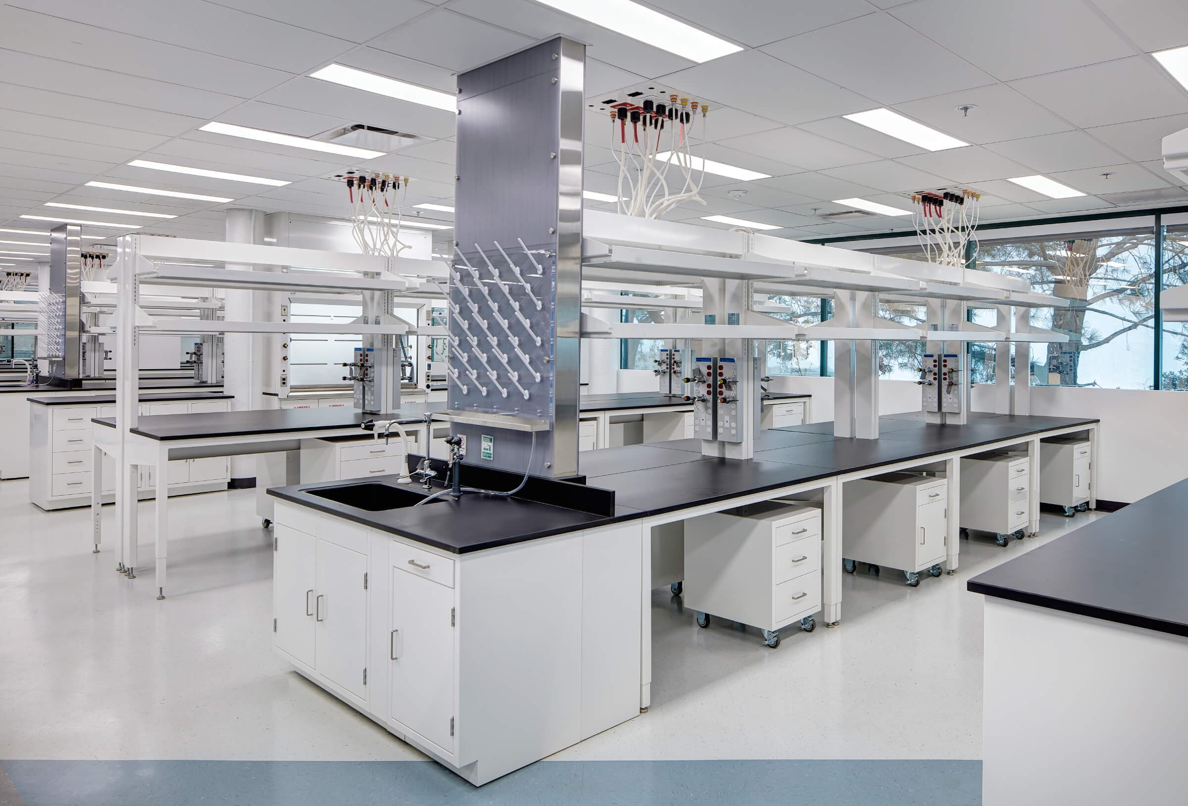 Laboratory interior at 11099 N. Torrey Pines Rd. in La Jolla, with white benches, fume hoods, and bright overhead lighting